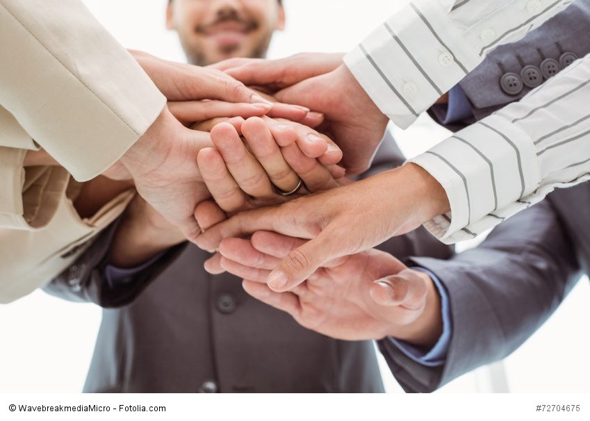 Close up of executives holding hands together